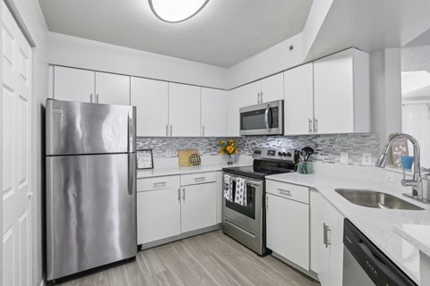 a kitchen with white cabinets and stainless steel appliances at Pembroke Pines Landings, Pembroke Pines, Florida